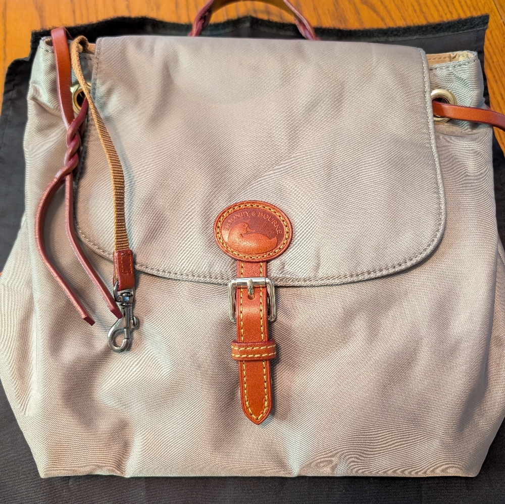 Dooney & Bourke Nylon Flap Backpack in a gray color with Straps.